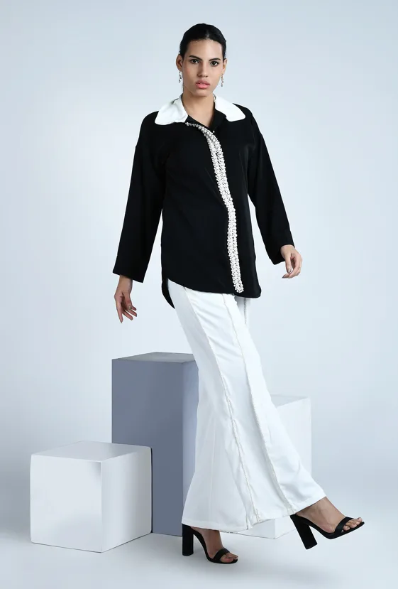Female model in a dynamic stepping pose wearing a black and white outfit for fashion photography