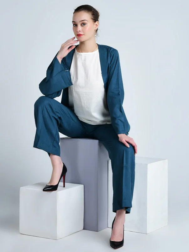 Female model seated in an elegant pose wearing a teal outfit for product photography
